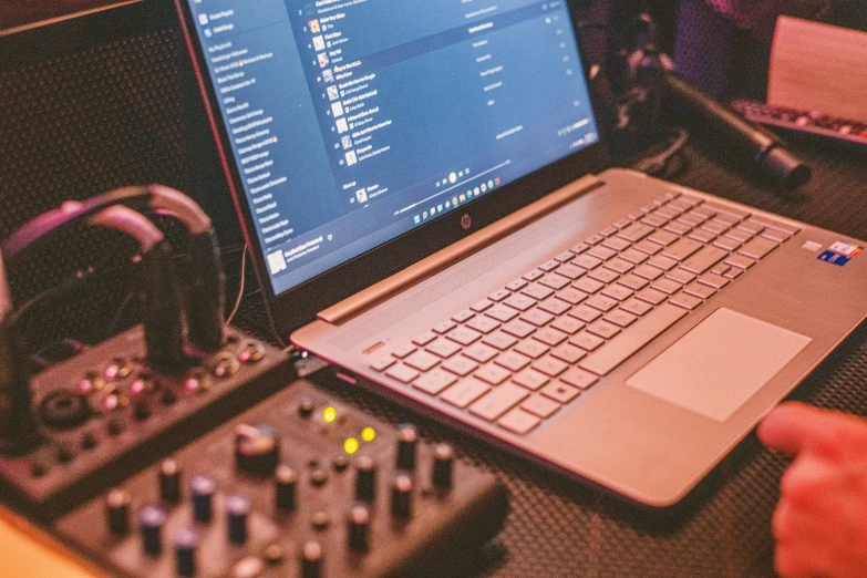 a laptop computer sits on top of some mixing equipment