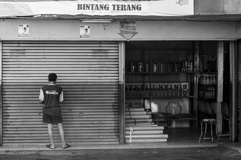 a man standing outside of a store near the door