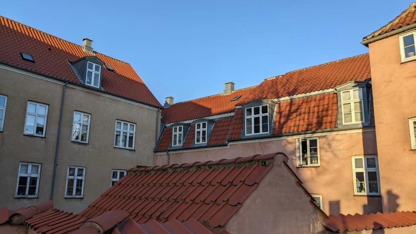 rooftops and windows of some buildings with red tile roofs