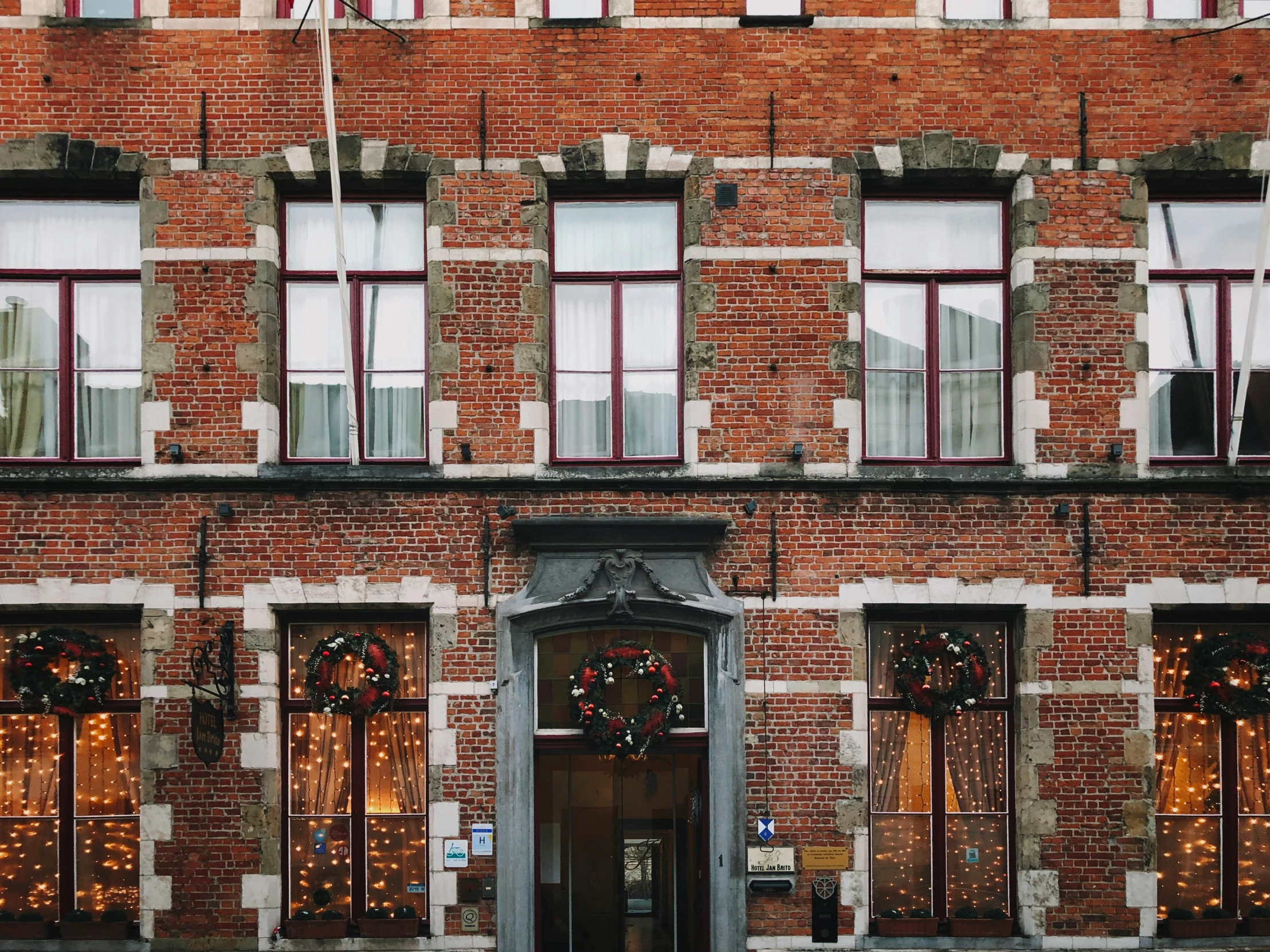 a brick building decorated with wreaths and garlands