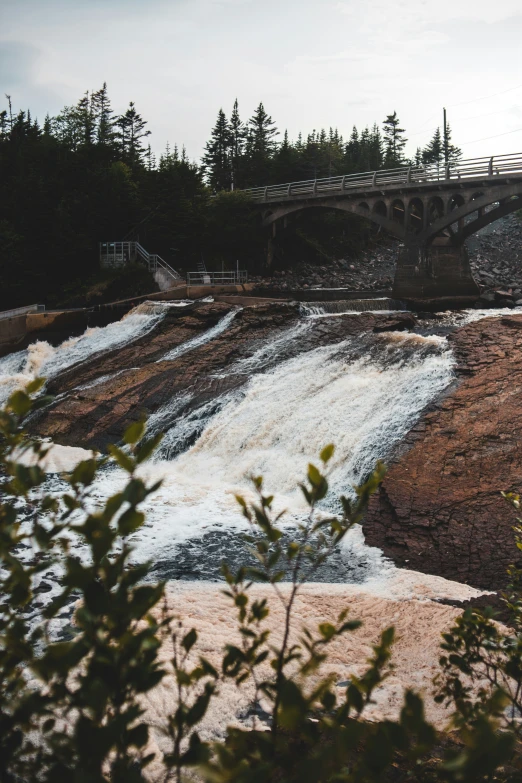 a waterfall and bridge in the back ground