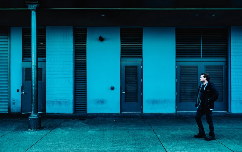 the man is walking down the street in front of a building