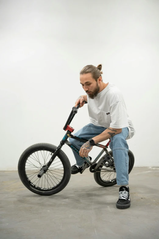 a man sits on a bike and adjusts his shoe