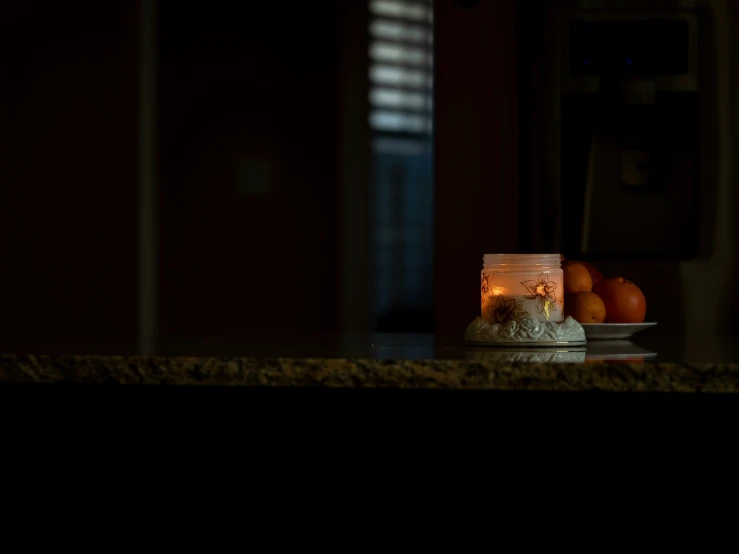 candle is lit up over a dish on the kitchen counter