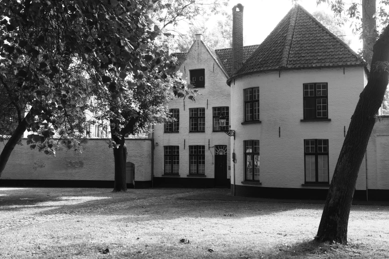 a white building with large windows near trees