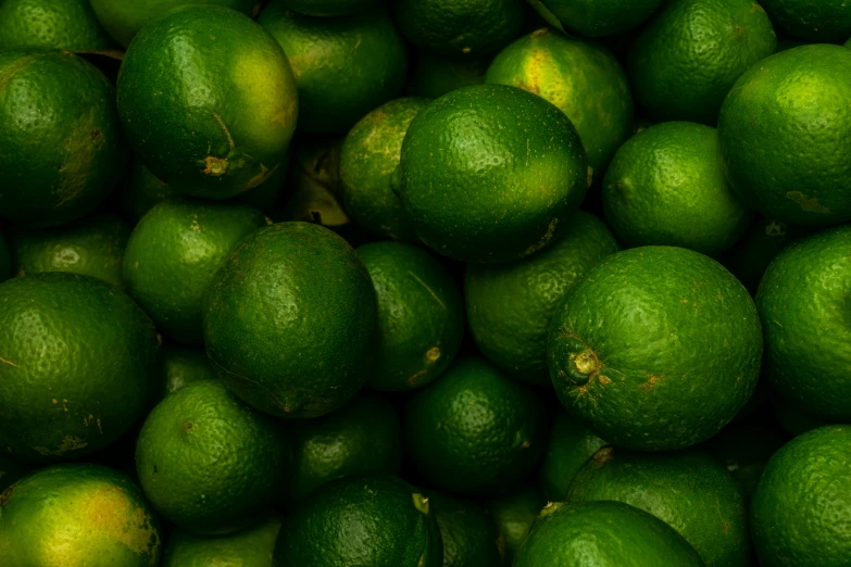 a pile of limes in green with the one on top of it
