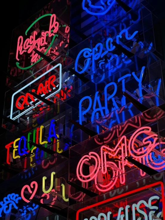 neon signs of different colors are hanging from the building