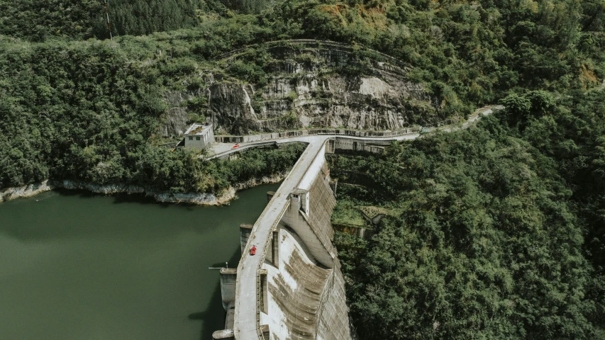 an aerial po of a bridge crossing a river with a mountain in the background