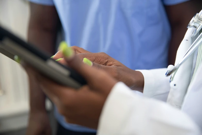 someone writing notes on their cell phone while holding a clipboard