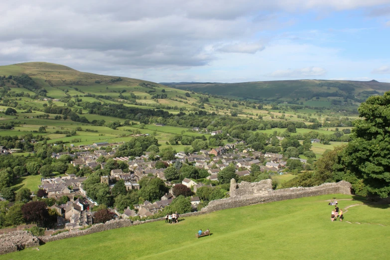 people are walking around an area with hills and green grass