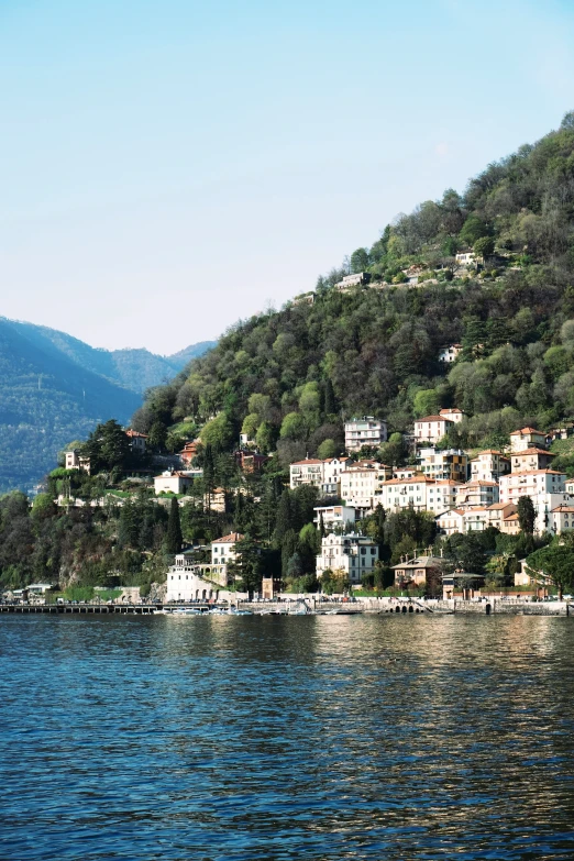 a city sits on the edge of a lake surrounded by mountains