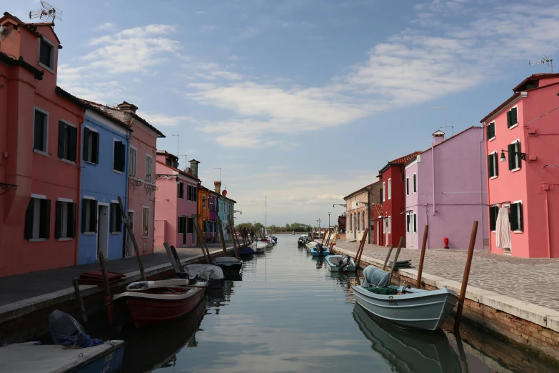 several boats are lined up along the water near a row of buildings