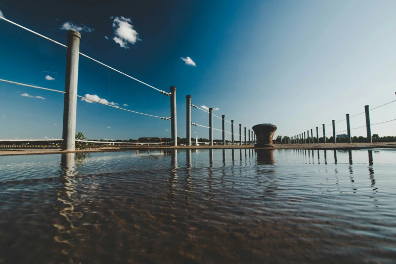large body of water next to power plant with many poles