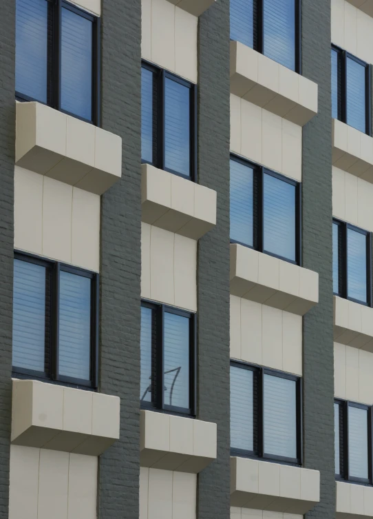 the side of a multi - story building has a wind vane near the windows