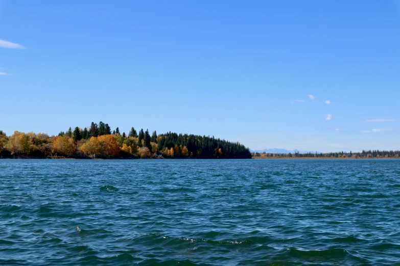 a long stretch of water with a small island in the distance