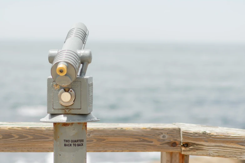 the telescope is set on a wooden pole near the water