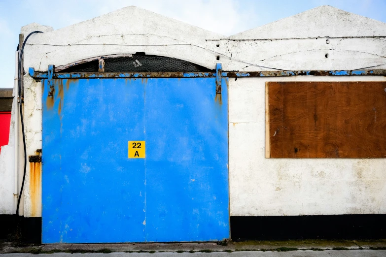 the front door of a colorful building with blue and yellow doors