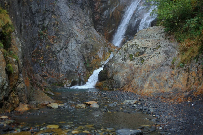 the water cascades down from the rocky cliffs