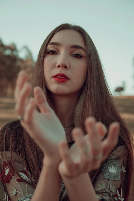 a woman wearing flowers and holding her hands open