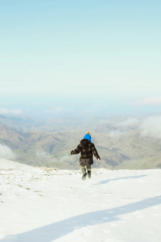 a person in a blue hat standing on snow covered ground