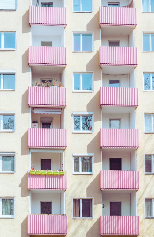 pink, stripe building with several balconies on each window