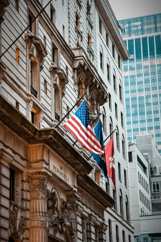 two flags and another american flag attached to a building