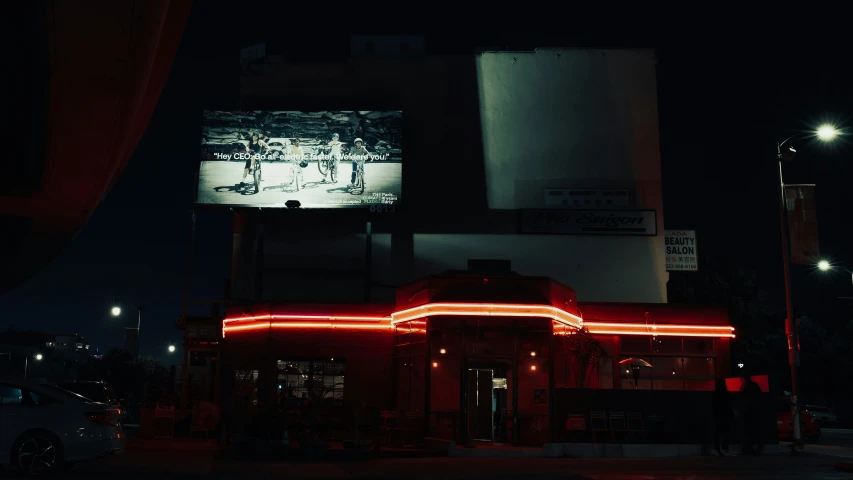 a red light at night illuminates a lit up diner