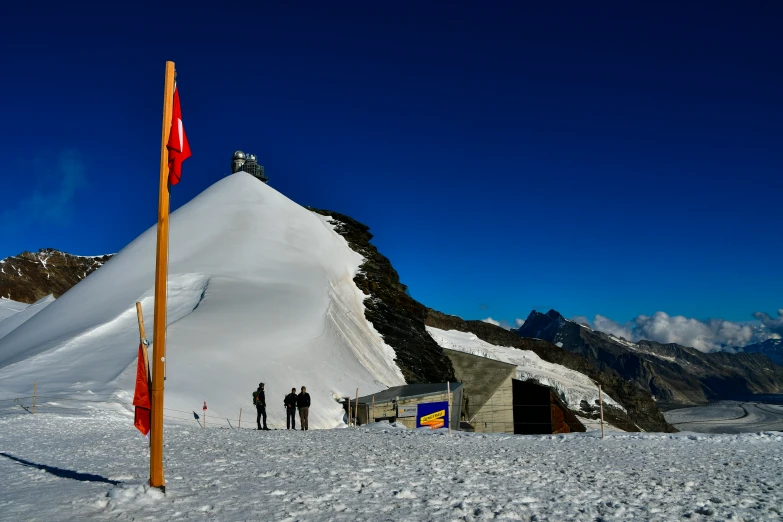 people are standing in the snow next to a mountain