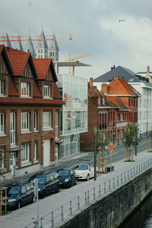 cars are parked along the street beside houses