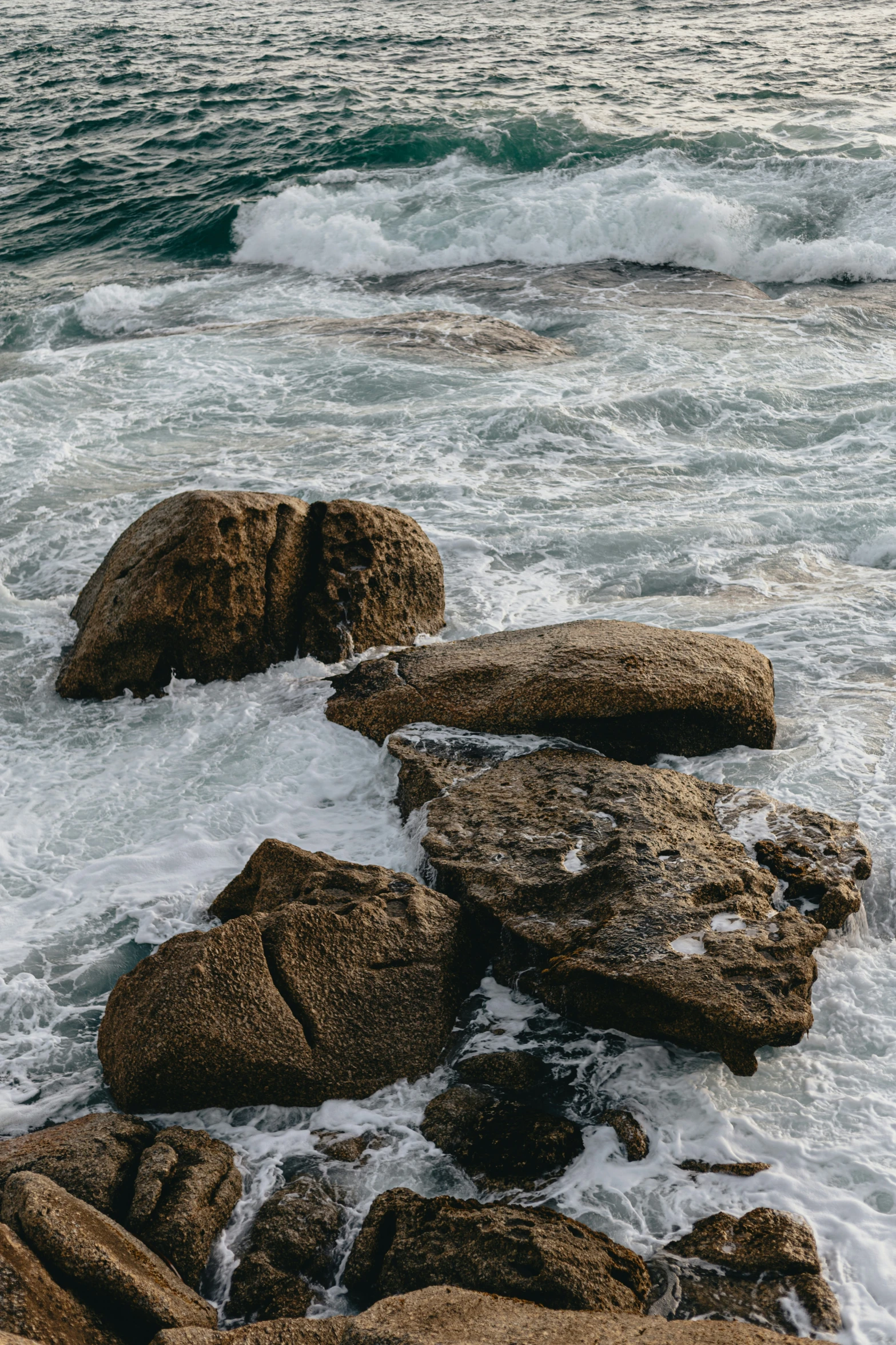 a large stone formation in the ocean with water rushing