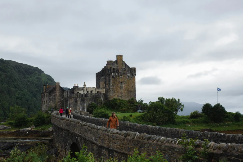 a castle that has people walking over a bridge