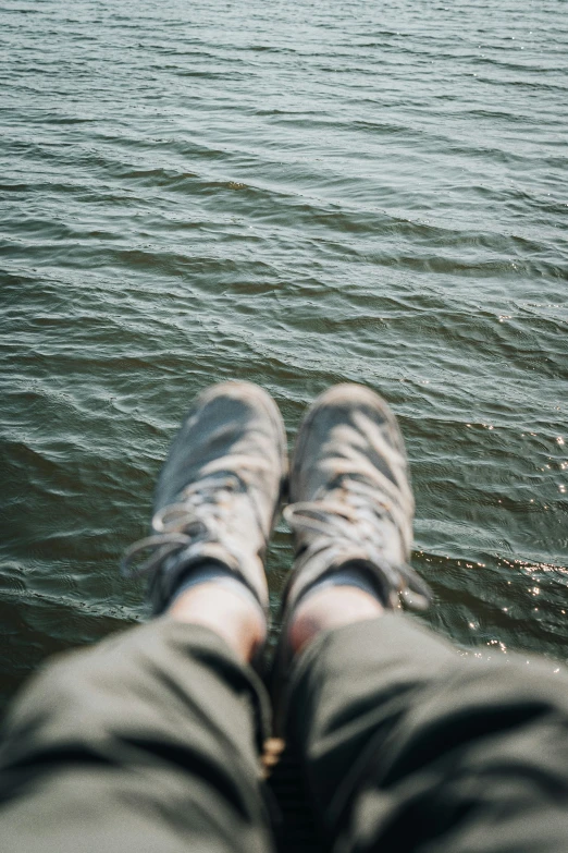 the person's feet are near water on a beach