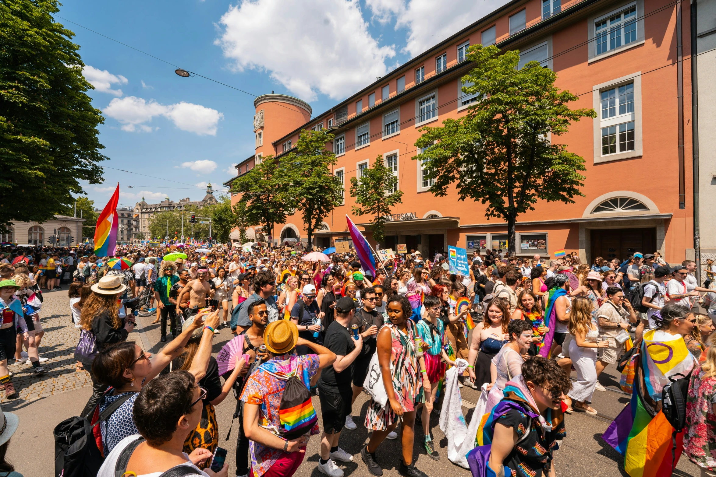 a crowd of people standing around each other near a building