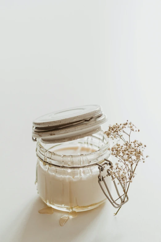 three glass jars filled with food items sitting on a white table