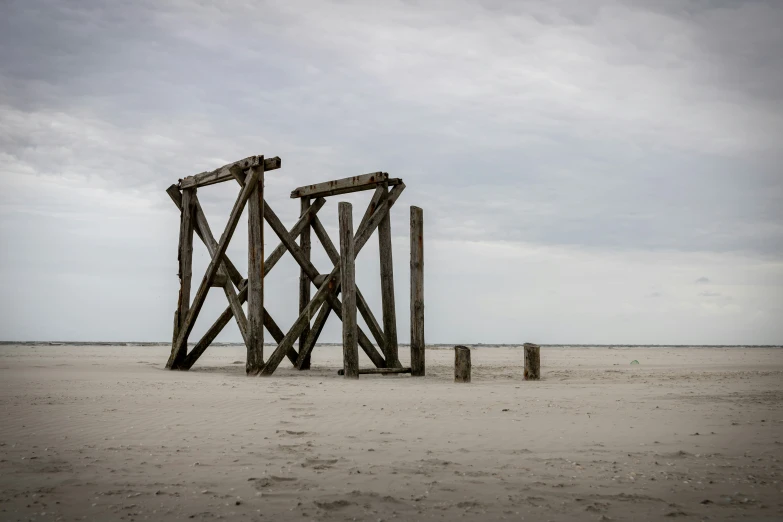 an old rusty fence sitting on top of the sand