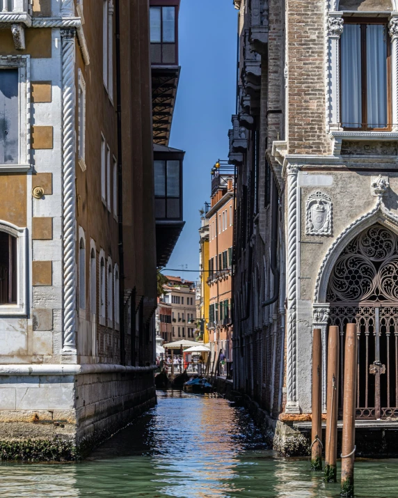 an alley with some buildings and a boat coming down the canal