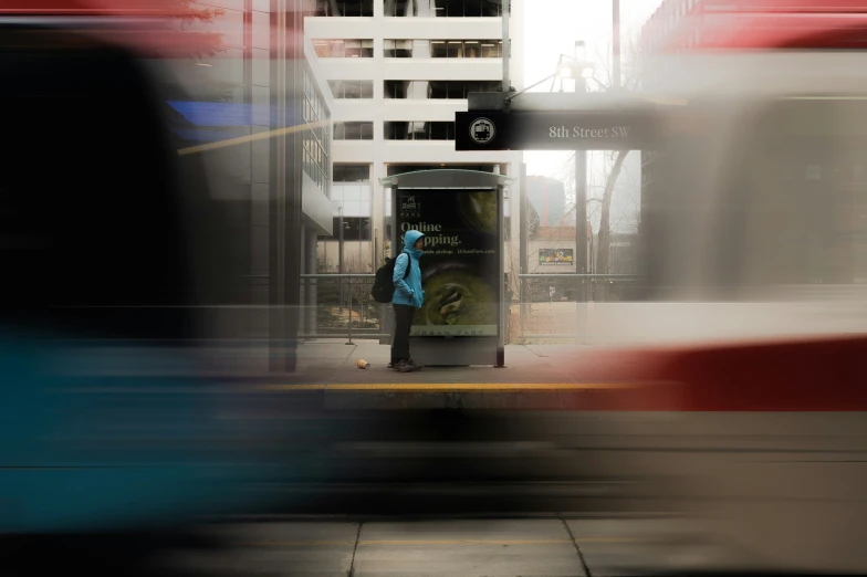 a person stands in front of a bus at the curb