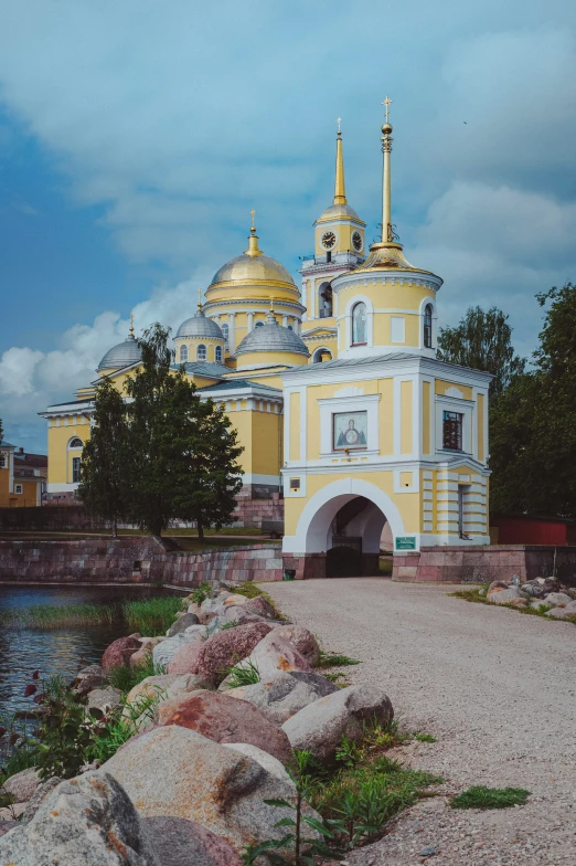 a yellow building with many gold domes near the water