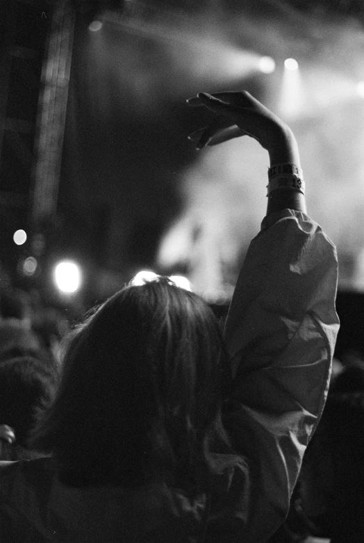 a person at a concert raising his hands in the air