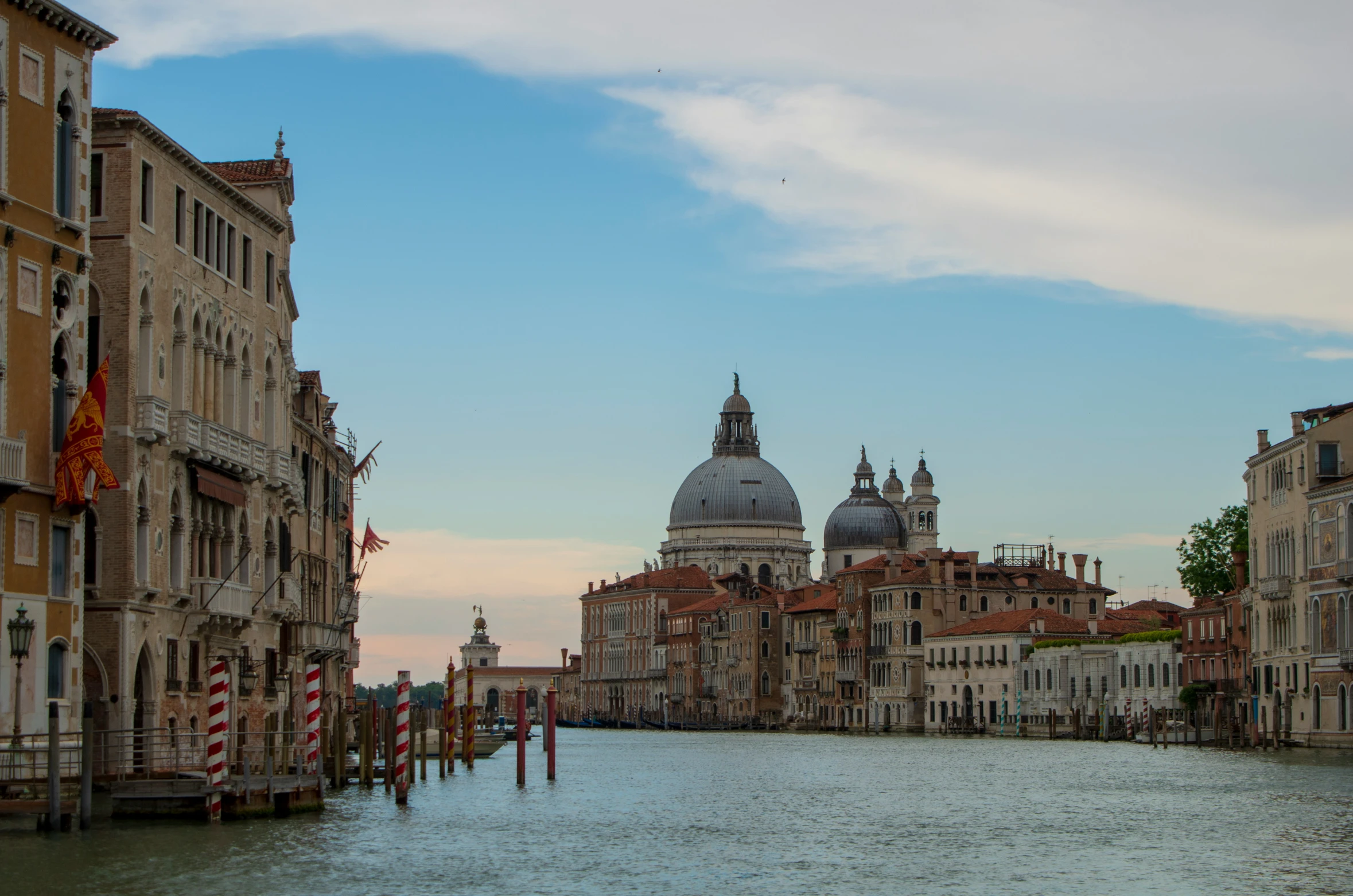 buildings line the waterfront as a boat glides on the water