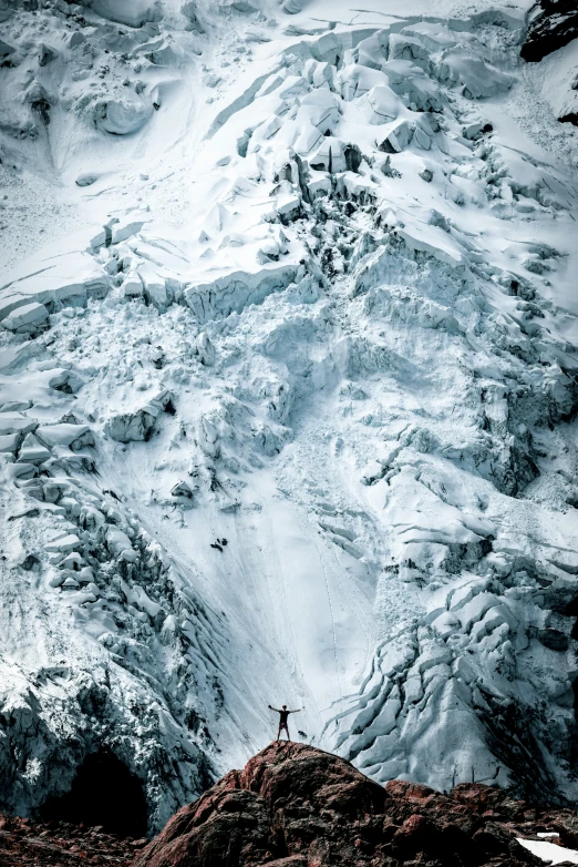 a mountain with a man standing on top of it covered in snow