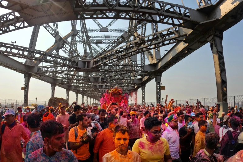 an elaborate crowd of people standing on top of a bridge