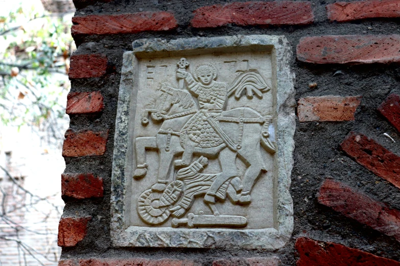 stone plaque with bird and horse design in wall
