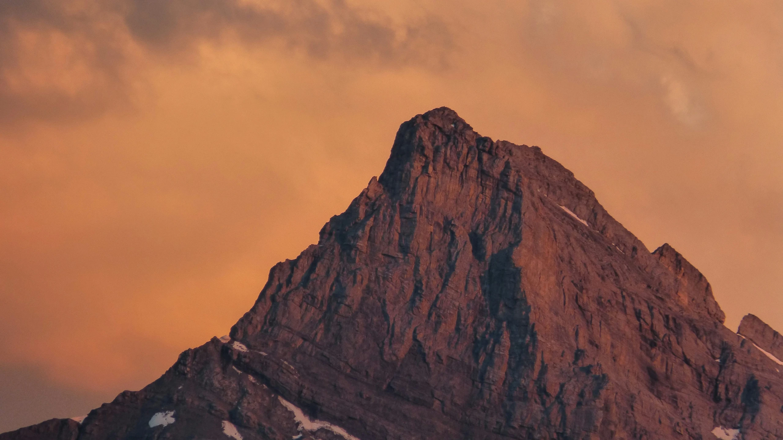 the top of a rocky peak with a cloudy sky