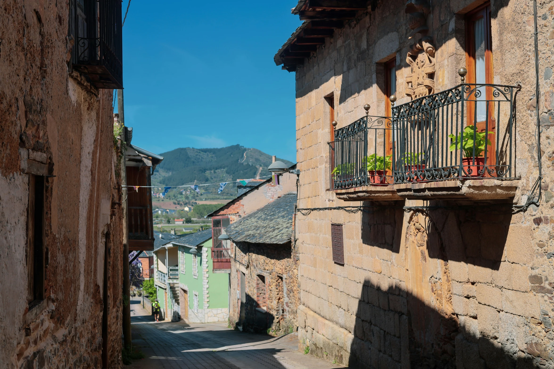 an alley way with pots full of flowers on each side of the road