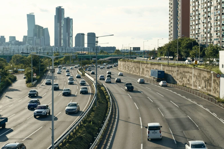 a wide city freeway with lots of vehicles and a bridge