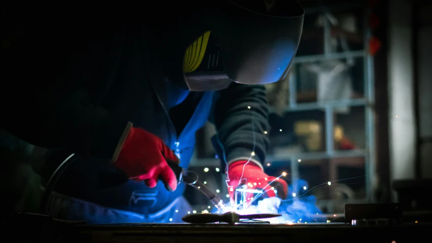 welder welding metal material in the dark