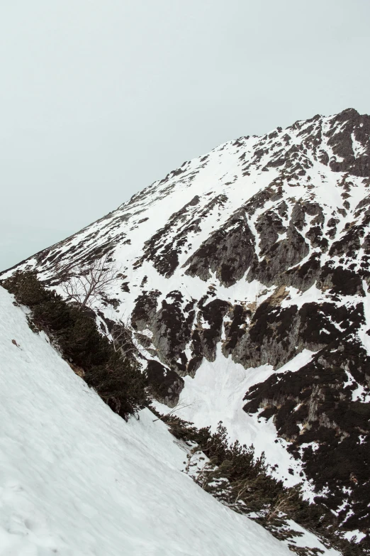 a man on a snow board is standing on the mountain