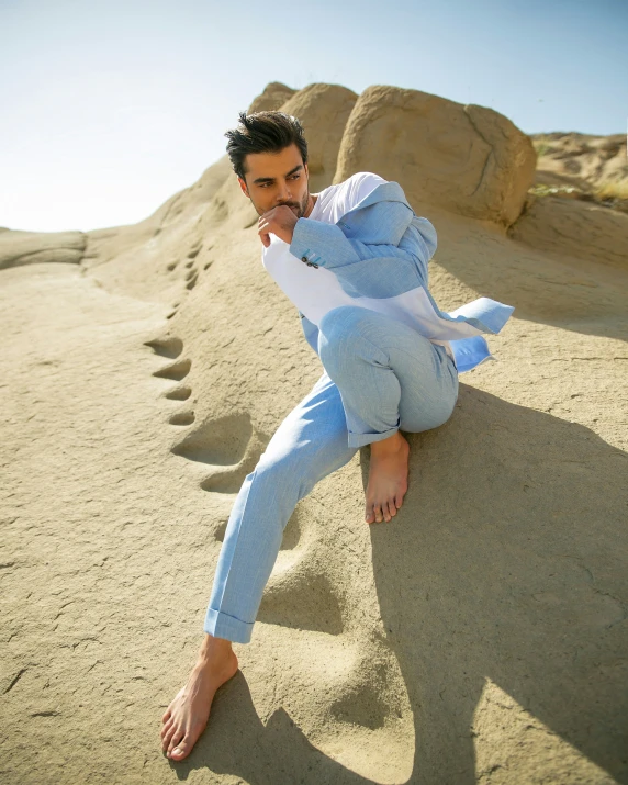 the young man is dressed in blue on the beach