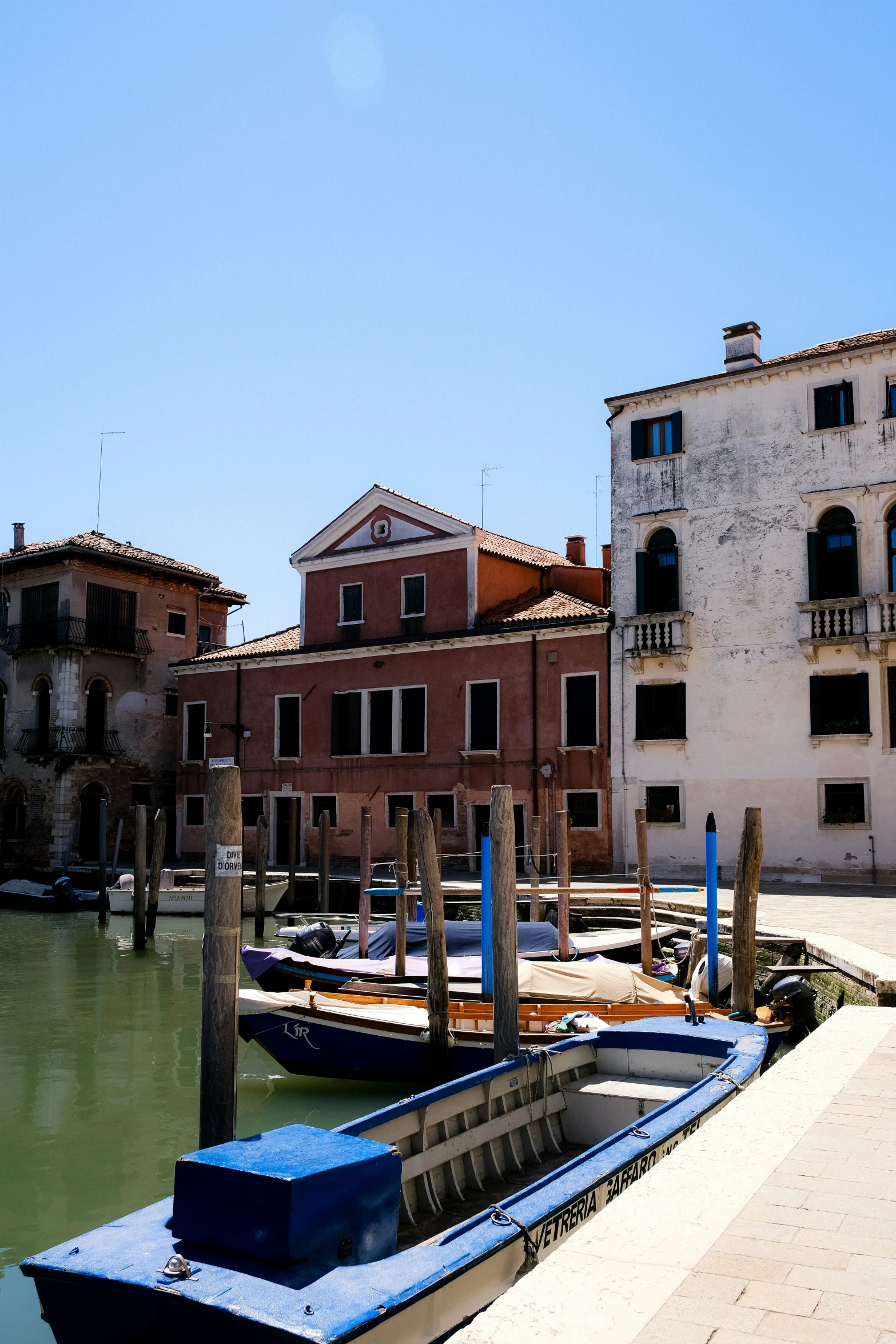 the blue boat is parked near the dock in the water